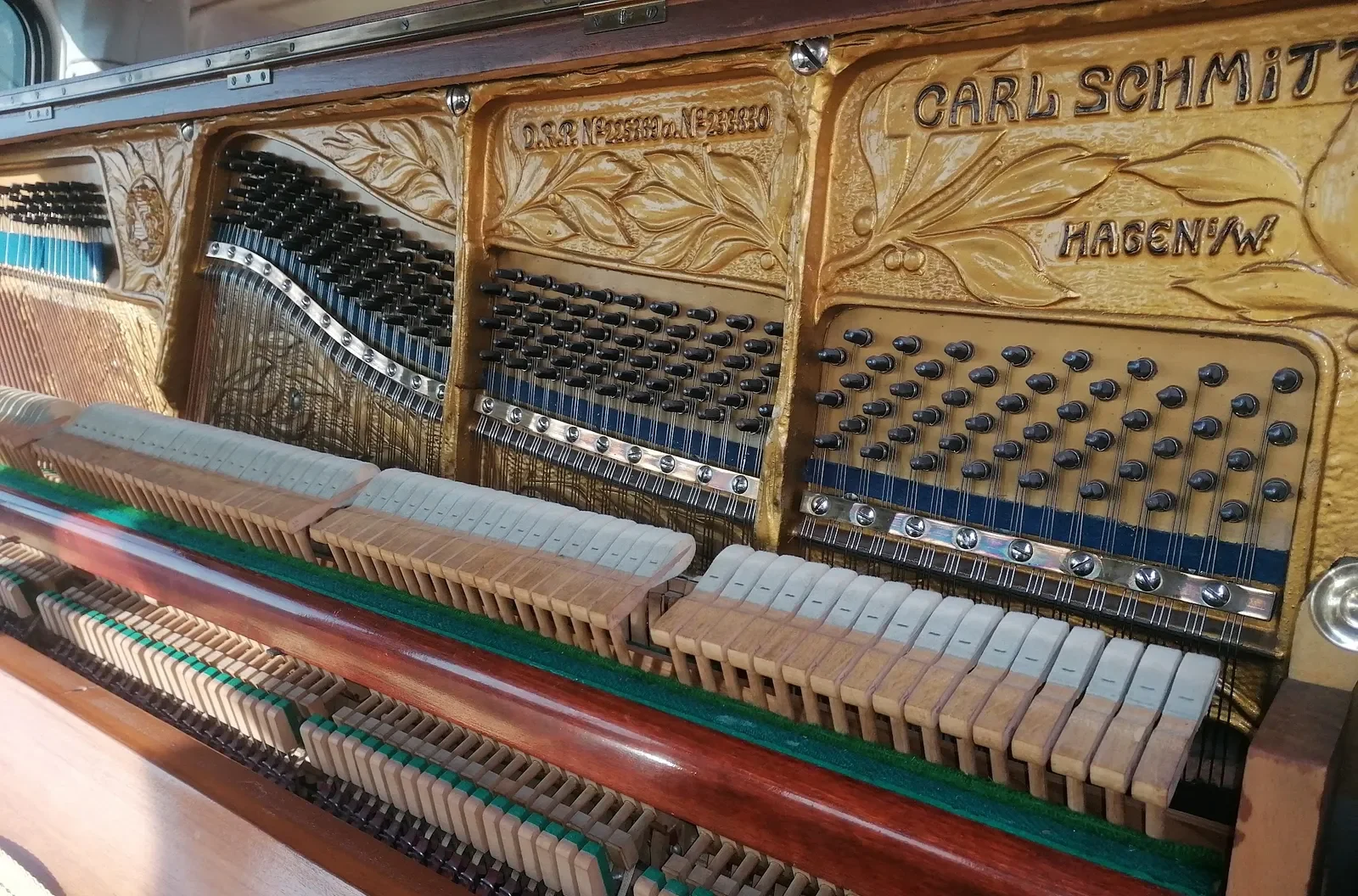 Historische Klaviermechanik mit Dämpferfilzen und Gussplattenprägung
